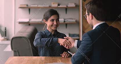 Indian and caucasian business partners shake hands finish formal meeting