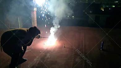 A person lighting fireworks to celebrate New Year Eve.