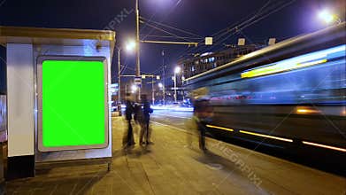 Billboard with a chroma key green screen on n bus stop at night. Time Lapse.