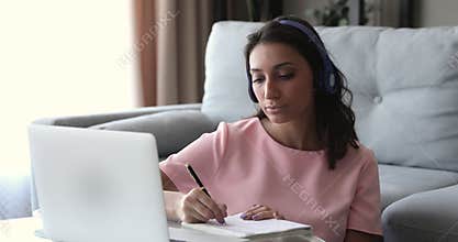 Focused young mixed race indian arabian woman studying remotely.
