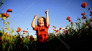 Happy baby child playing and jumping in poppy flower field at summer day. Childcare and childhood. Valentines day kids