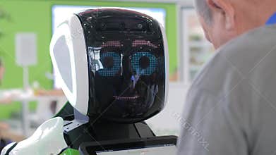 White cute robot with display face speaking with people - close up view