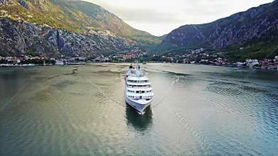 Aerial view of luxury cruise ship sailing from port on sunrise through the bay