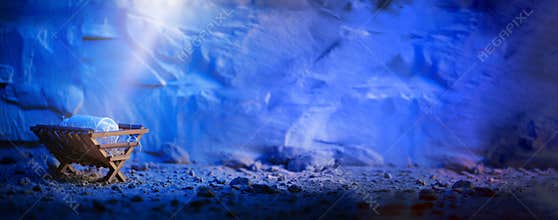 Wooden manger and star of Bethlehem in cave, nativity scene background. Christian Christmas concept. Birth of Jesus