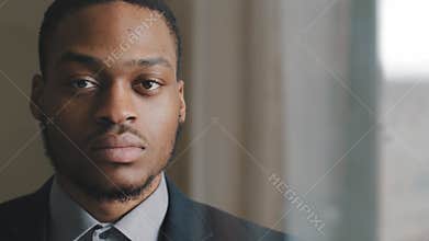 Portrait of serious focused pensive dark-skinned business man afro american investor looking out window in office