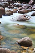 Pebbles in creek flowing water