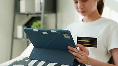 Woman holding tablet and credit card with paying for shopping online