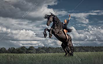 Little ballerina girl with black friesian stallion