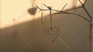 Creative composition in neutral colors for Valentine`s Day. Hearts on a branch in a vase on the table.