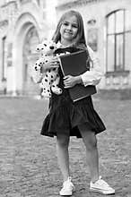Learning and fun for everyone. Happy kid hold books and toy. Back to school supplies. School uniform. Formal fashion