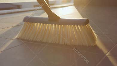 Broom sweeping away dust dirt. Spring cleaning and Domestic house keeping. Flare