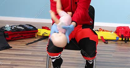 Close up, instructor performs CPR on baby training doll. First aid training. Paramedic show how to do CPR on a doll dummy for
