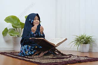 A Little muslim girl pray on the prayer rug on Ramadan Kareem