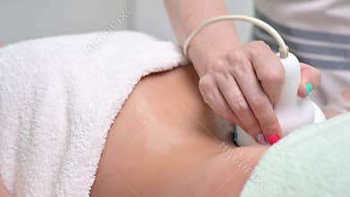 Woman getting ultrasound cavitation treatment by cosmetologist. female client enjoying anti-cellulite procedure at