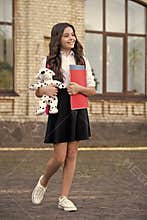 My school is fun. Happy child hold books and toy outdoors. Back to school supplies. Formal fashion. Primary education