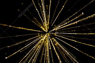 Golden star burst light pattern against a black background