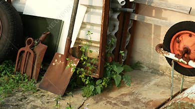 View of abandon wheelbarrow, tired and some old rusty labor tools.