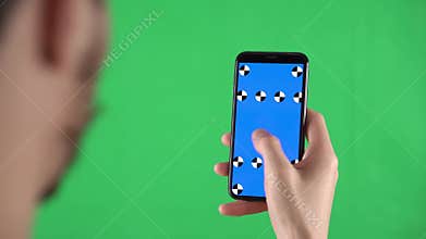 Man holds smartphone with tracking markers on the display and swiping left then tap on touch screen