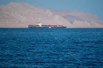 Bukha, OMAN - MAY 28 2021: Iranian coastline near the Strait of Hormuz. giant sea container ship in the strait of Hormuz