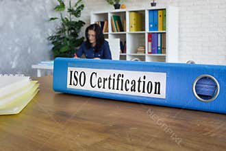 Folder with guide about ISO certification on the table.