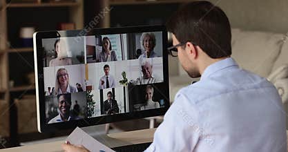 Over shoulder view male worker meet colleagues online at videoconference