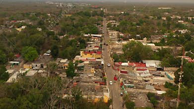 Aerial view of cars driving on street in poor suburban. Low one floor buildings in town. Valladolid, Mexico