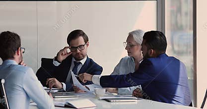 Diverse colleagues reviewing sales results, analyze revenue gather in office