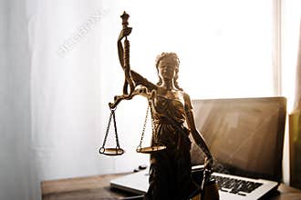 law legal technology concept. judge gavel on computer with scales of justice on desk of lawyer