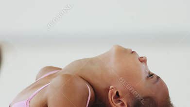 Two little girls gymnasts bending their back on training