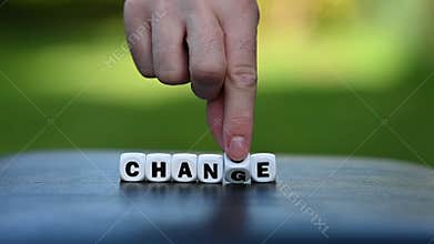 Hand is turning a dice and changes the word change to chance
