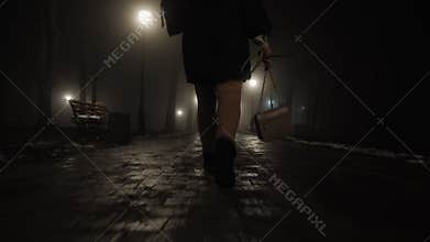Woman walking in city park at night