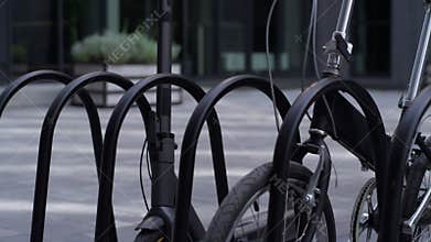 Closeup electric scooter standing at shared parking together with black bicycle.