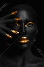 Beauty woman black skin color body art, gold makeup lips eyelids, fingertips nails in gold color paint. Professional gold makeup