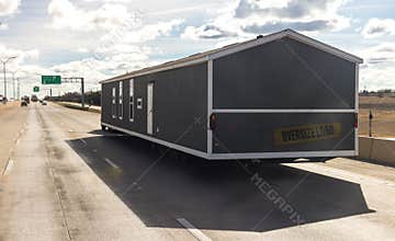 Mobile house transportation. Transporting portable home on the highway in Texas. Oversize logistics, semi truck carries a large pr