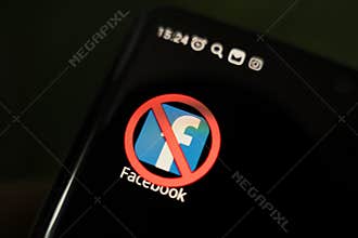 A crossed-out icon on a black smartphone screen. concept of banning the application facebook