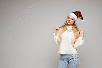 Pretty blonde in Santa hat smiling at camera.