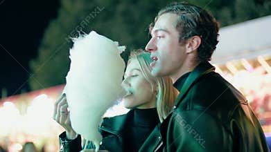 Couple Spend Time at Amusement Park and Eat Cotton Candy .