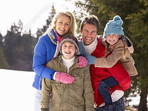 Young Family In Alpine Snow Scene