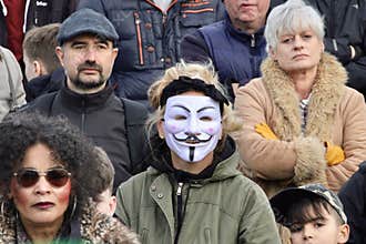 Woman Wearing Vendetta Mask in a Crowd