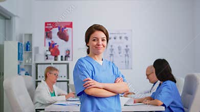 Portrait of young nurse standing in front of camera smiling