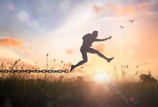 Silhouette Man Jumping Over Broken Chain for Freedom and Spiritual Resurrection Concept