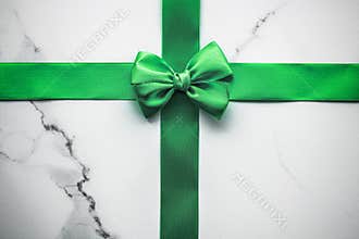 Green silk ribbon and bow on marble background, St Patricks day present or Christmas glamour gift decor for luxury