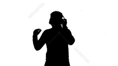 Silhouette Smiling African american man in headphones and moving to the music rhythm.