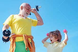 Senior man and child exercising on blue sky. Healthcare cheerful lifestyle. Portrait of a healthy Father and son working