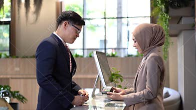 Contactless payment. Business man use credit cards to pay for young women employees