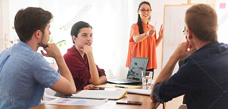 Female colleague briefing to her other friends in office