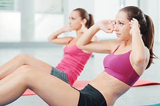 Young women doing abs workout at the gym