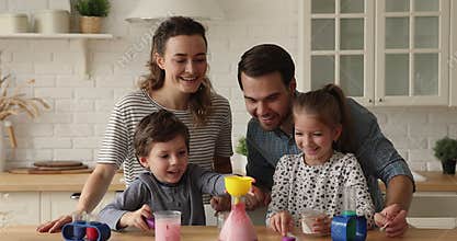 Couple and kids playing with chemistry science hands-on kit