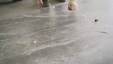 Laying floor ceramic tile. Renovating the floor. Construction workers laying tile over concrete floor using tile