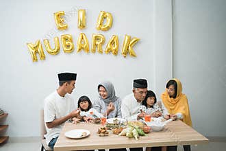 beautiful asian family enjoying their iftar dinner at home